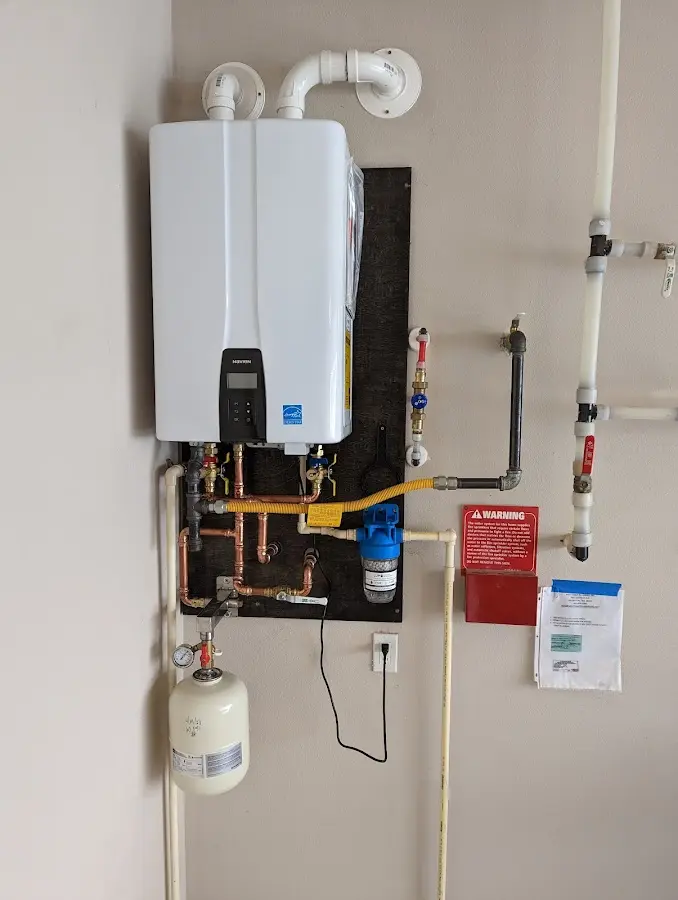 Professional plumber installing copper piping in a Mancelona home